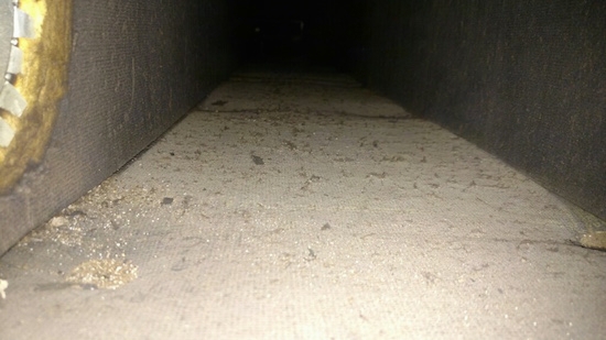 A view from the inside of a fiberglass lined duct with an air vent going off to the left