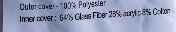 Close up of the memory foam mattress label that reads 'Outer cover - 100% Polyester - Inner cover: 64% Glass Fibers 28% acrylic 8% Cotton'