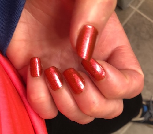 A hand with the nails painted a bright red color
