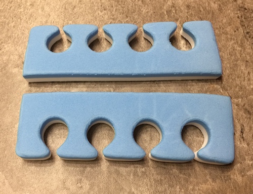 A synthetic blue and white memory foam toe and nail separator